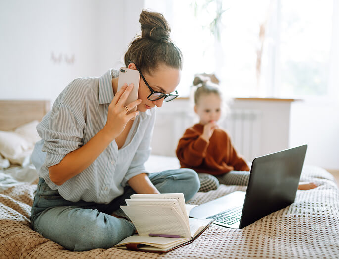 Mom with home phone and laptop home with young baby